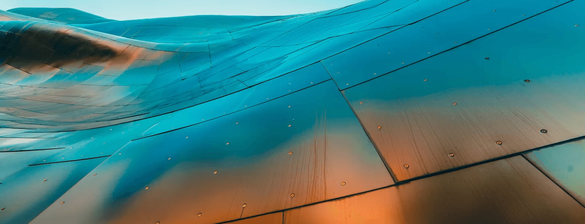 Abstract turquoise glass panels with orange reflections and water droplets in modern architectural design