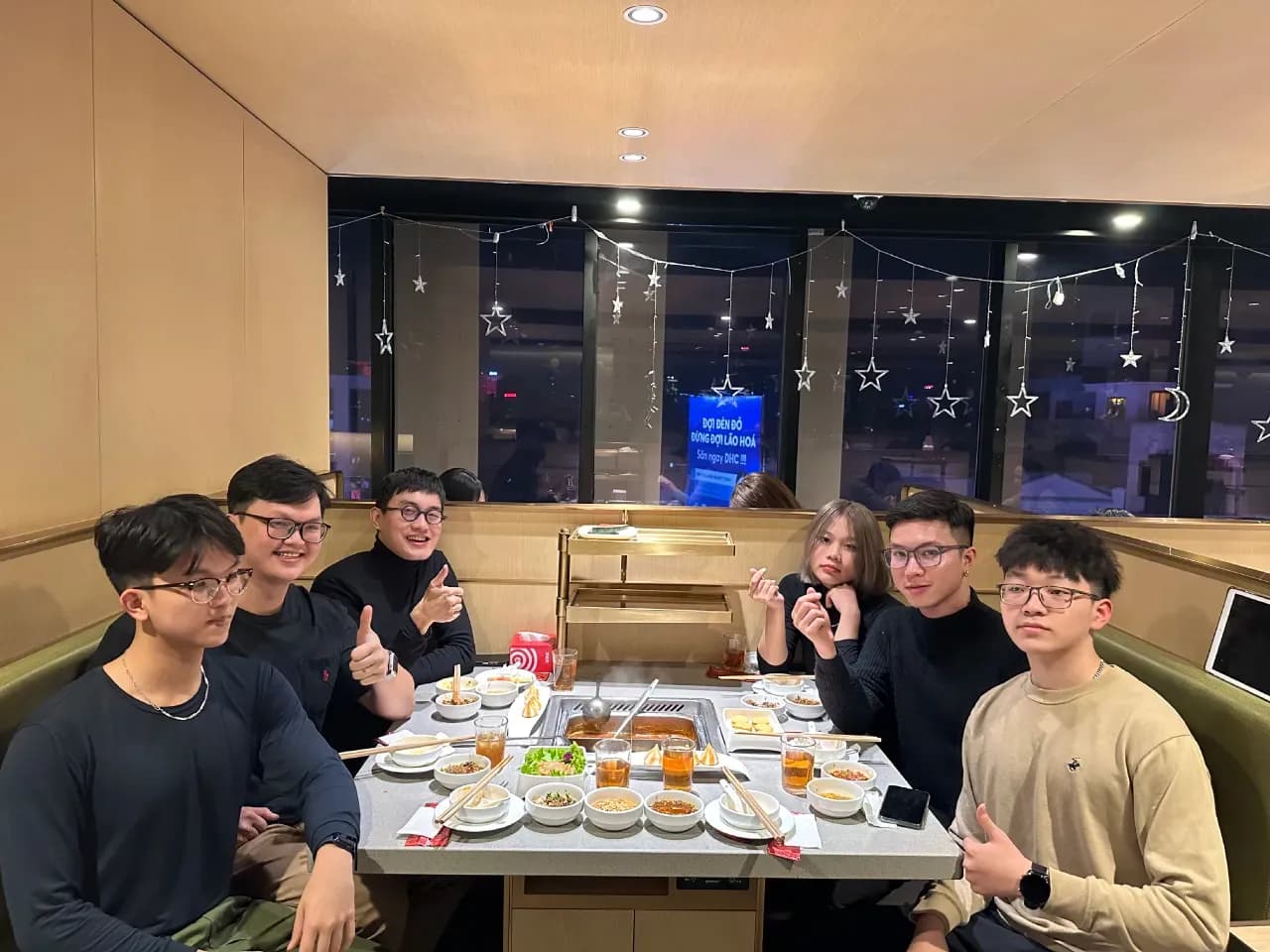 Group of students celebrating at a birthday party with snacks and drinks in a cozy indoor venue