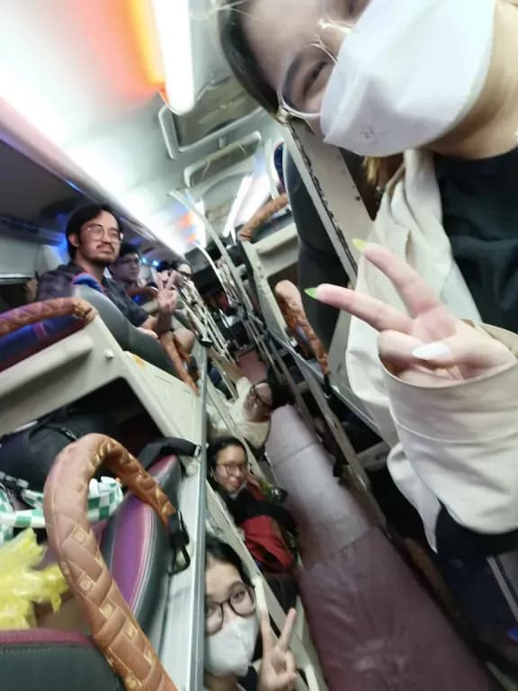 A worker in protective gear offers a peace sign inside a crowded aircraft cabin, airplane safety and transit